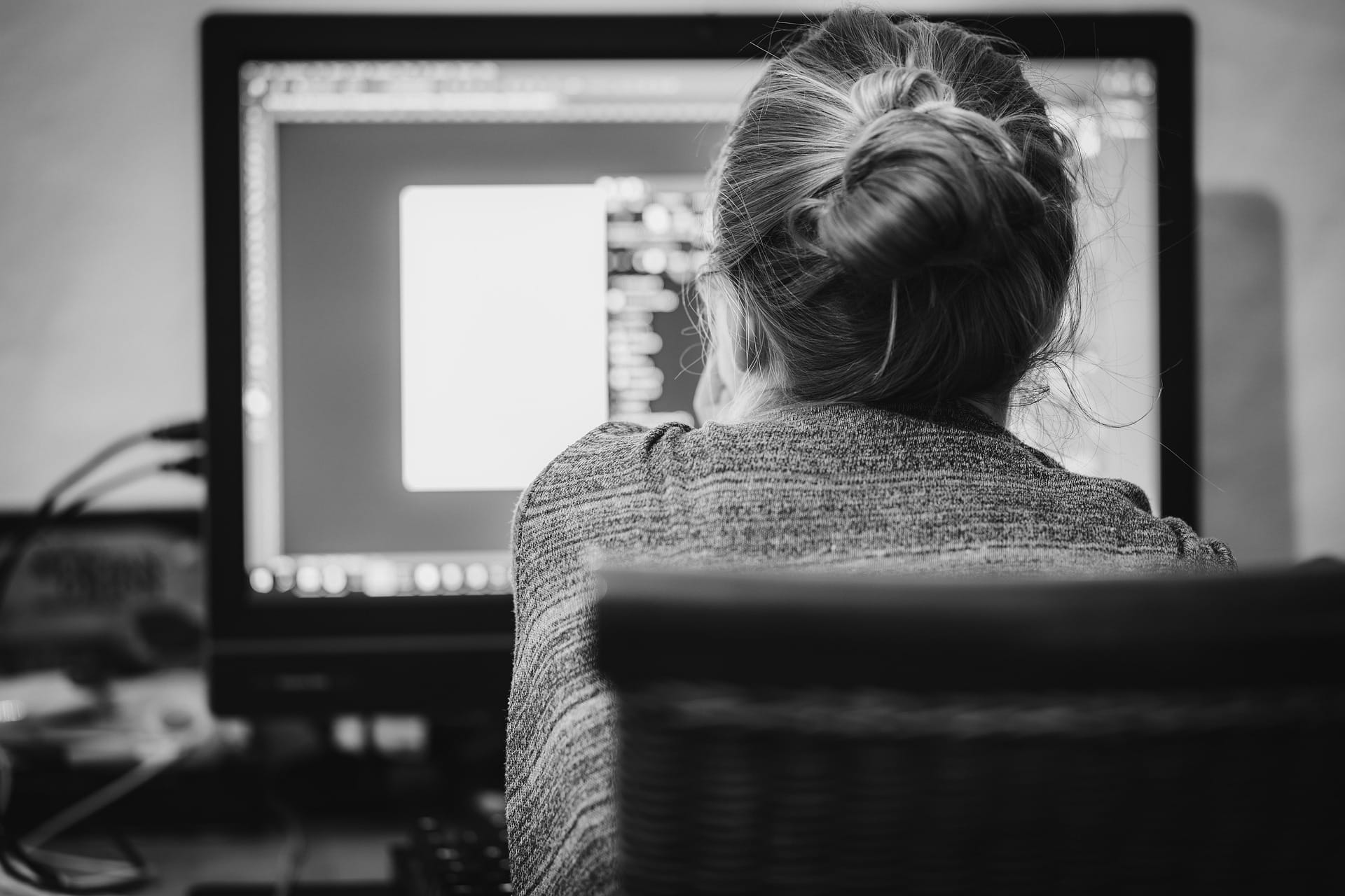 Nonprofit professional sitting at a computer, representing barriers to AI adoption in the nonprofit sector