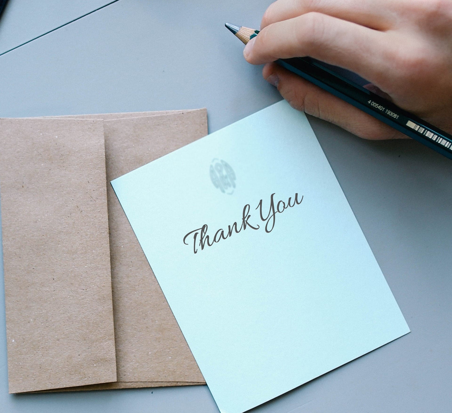 Person handwriting a thank you note to a nonprofit donor representing personal stewardship AI cannot replace