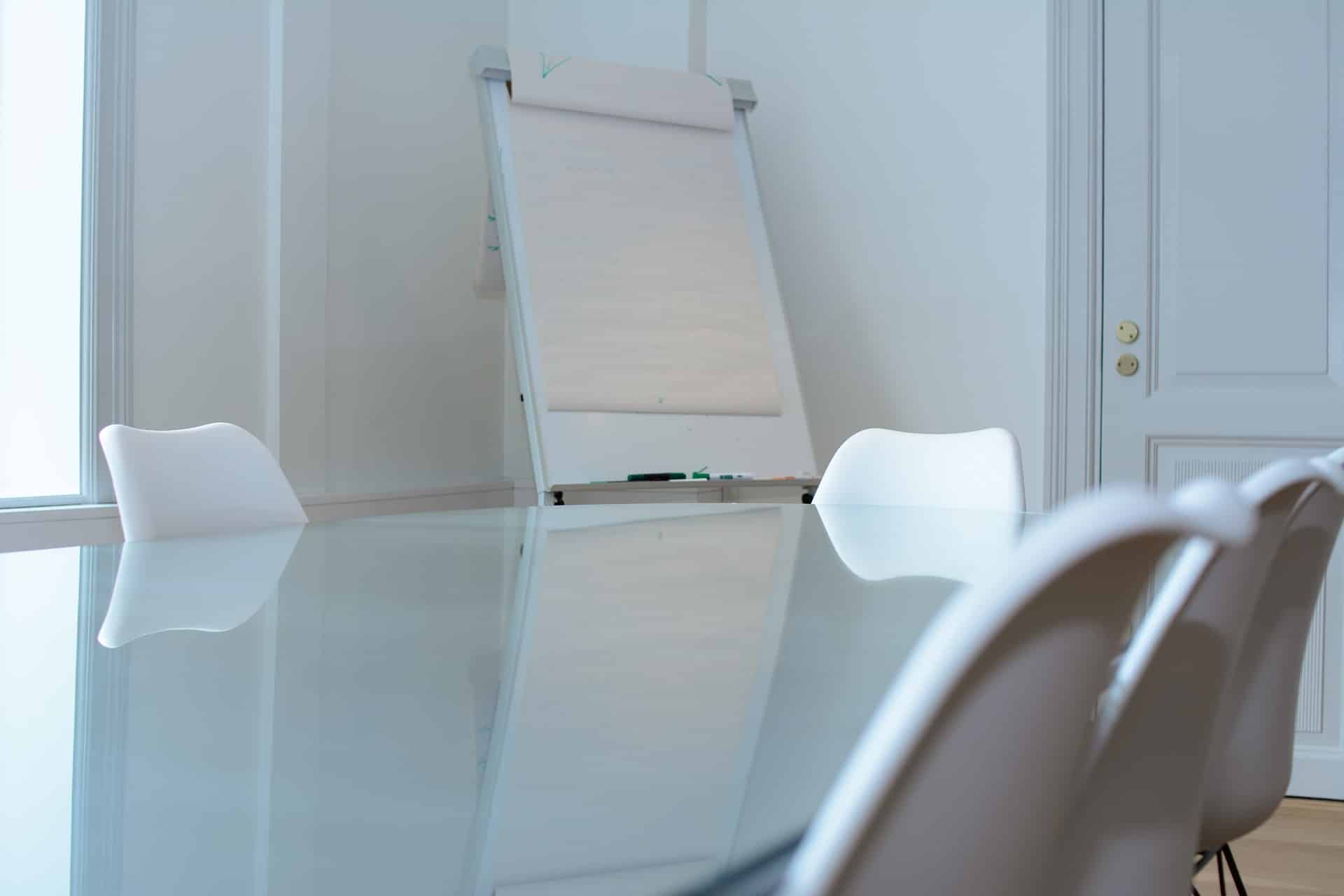 ebersmith-health-check-lite-workspace A modern, bright workspace with a white glossy table and easel, representing the focused environment of the Board Health Check Lite assessment for nonprofit Executive Directors and Board Chairs