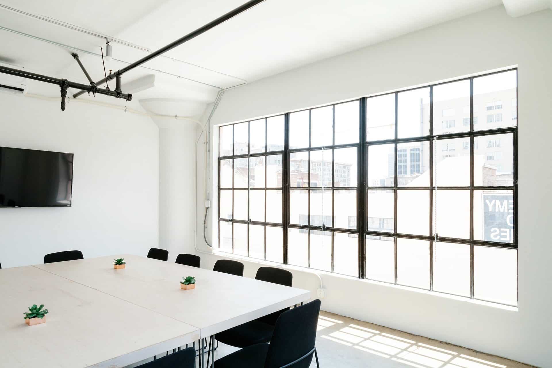 A bright, modern industrial boardroom with large windows and a clean meeting table, representing the collaborative retreat facilitation by ebersmith coaching & consulting
